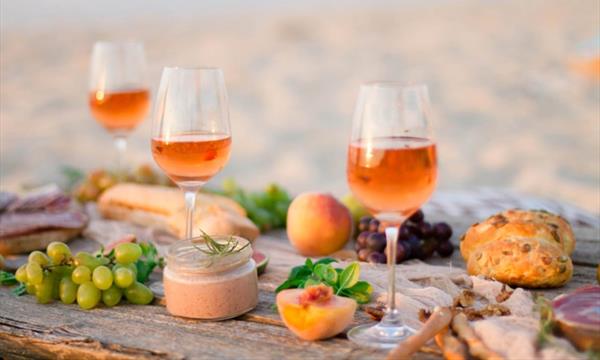 Orange wine on a beach with food