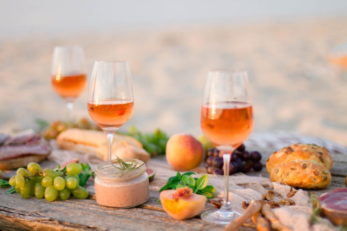 Orange wine on a beach with food